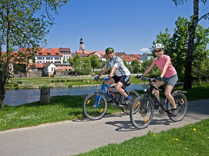 Radelfahren im Bernhard-Wicki-Wäldchen mit Blick auf die Stadtsilhouette